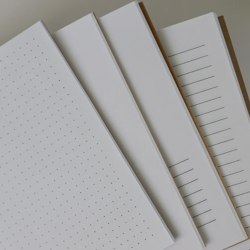 Set of handmade notebook pages with different grid patterns on a light gray background