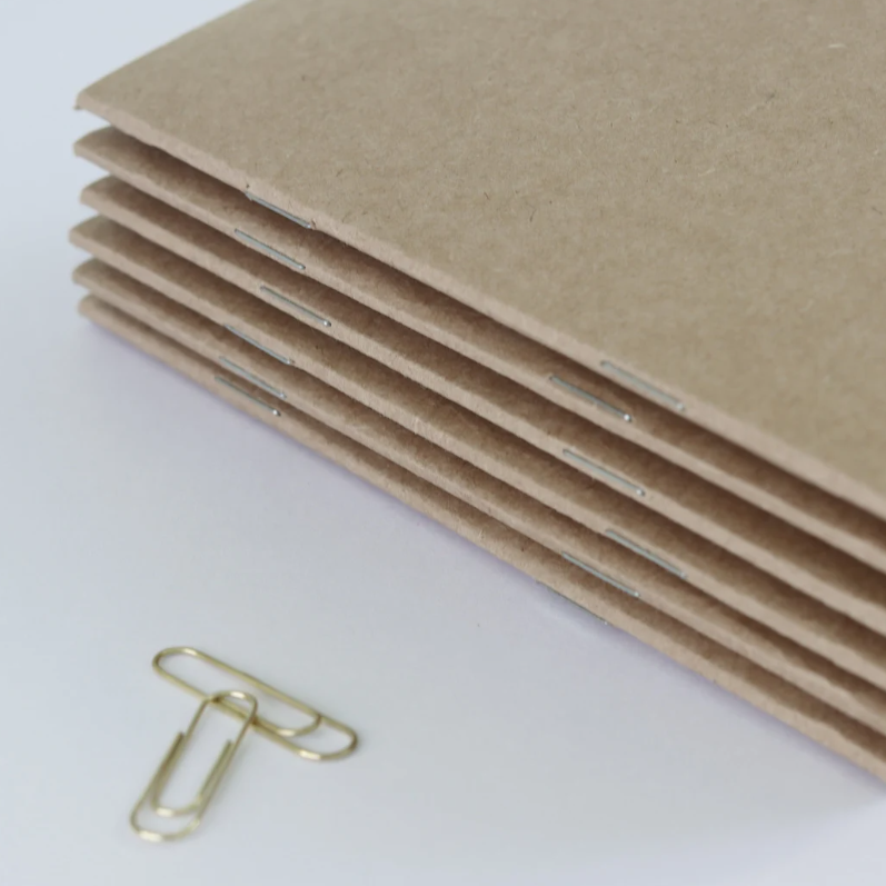 Stack of kraft card handmade notebooks that can be personlised for business or events.  Promotional product idea.
